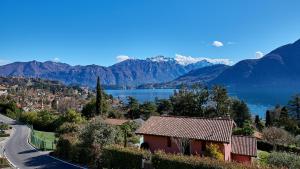 a house on a hill with a lake and mountains at Design Villa in Tremezzina Villarnona Lake Como in Mezzegra +81 photos
