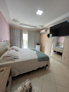 a bedroom with a large bed and a large window at Casa maria Júlia in Araguaína