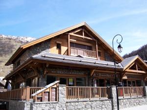 a large wooden building with at Chalet Les Pins - 3 Pièces pour 6 Personnes 84 in Valloire