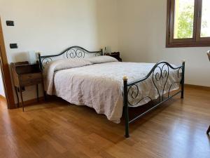 1 cama en un dormitorio con suelo de madera en Monte Pagliaio, en Terra del Sole