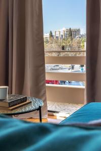 una mesa con un libro y una taza y una ventana en Home of Petros, en Atenas