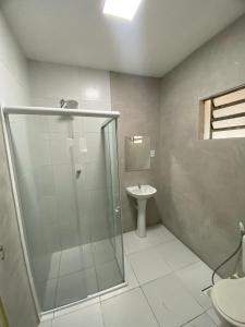 a bathroom with a glass shower and a sink at Pousada Manaíra in João Pessoa