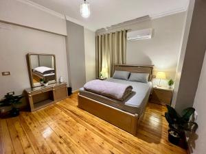 un dormitorio con una cama y un espejo en Modern 2BR Apartment in Maadi, en El Cairo