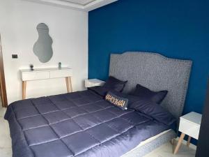 a blue bedroom with a bed and a white table at jasmin in El Aouina