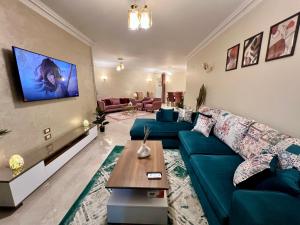 Una sala de estar con un sofá azul y una mesa. en Modern 2BR Apartment in Maadi, en El Cairo