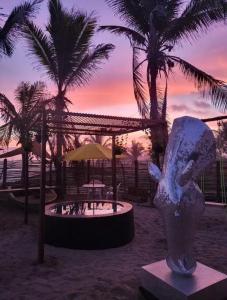Copala的住宿－Norock club y Playa，棕榈树海滩上的鸟雕像