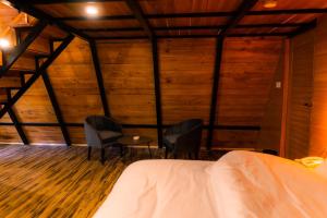 a bedroom with two chairs and a bed in a room with wooden walls at Maple Resorts in Skardu