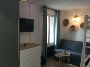 a living room with a blue couch and a tv at Appartement bord d'océan dans résidence 3*** avec piscine et parking privé in Mimizan-Plage