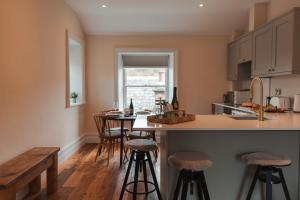 a kitchen with a island with bar stools and a window at The Jodrell Luxury Suites in Whaley Bridge