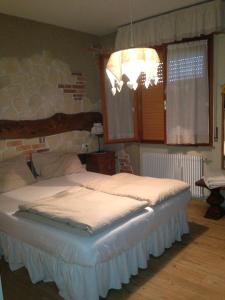1 dormitorio con 1 cama grande y lámpara de araña en Locanda Al Cacciatore, en Seren del Grappa