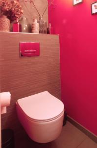 a bathroom with a pink toilet and a pink wall at Cozy Canal Studio in Amsterdam