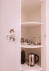 a cupboard with a tea kettle and other items at Cozy Canal Studio in Amsterdam