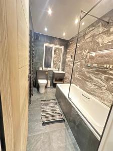a bathroom with a tub and a sink and a toilet at Smiddy Cottage Bauds in Buckie +14 photos