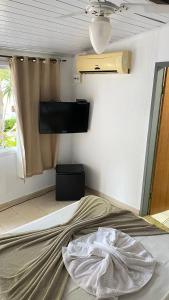 een slaapkamer met een bed en een flatscreen-tv bij Nova Estrela Geriba in Búzios