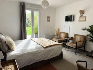 サン・ヴァレリー・シュル・ソンムにあるLa Villa Saint Valのベッドルーム1室(ベッド1台、椅子2脚、窓付)