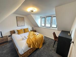 a bedroom with a bed with a yellow blanket on it at Smiddy Cottage Bauds in Buckie