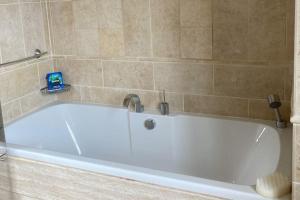 a white bath tub in a bathroom at Yellowstone, The Garden Apartment in Radstock
