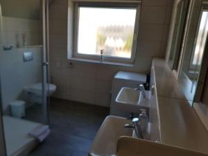 ein Bad mit 2 Waschbecken, einem Fenster und einem WC in der Unterkunft Cosy apartment in Porta Westfalica in Porta Westfalica