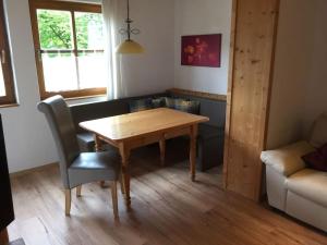 sala de estar con mesa de madera y sofá en Snug apaartment in Oberammergau, en Oberammergau