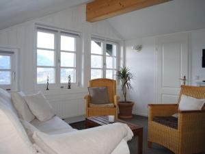 uma sala de estar com um sofá, cadeiras e janelas em in the Berghanghäus"l Obersalzberg em Berchtesgaden