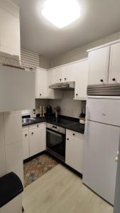 eine Küche mit weißen Schränken und einem schwarzen Gerät in der Unterkunft CasacheloCangas in Cangas