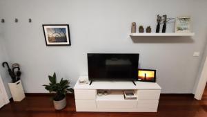 uma televisão num armário branco numa sala de estar em CasacheloCangas em Cangas