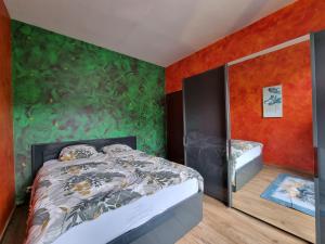 ein Schlafzimmer mit einem Bett und einer grünen Wand in der Unterkunft Bella vista in Durbuy