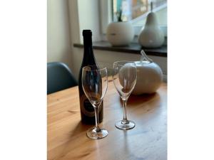 een fles wijn en twee glazen op een tafel bij Nice apartment in Hopfen am See in Hopfen am See