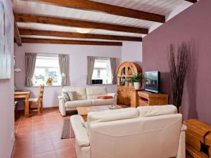 uma sala de estar com um sofá branco e uma televisão em Müller's apartment in the Nordermühle em Pellworm