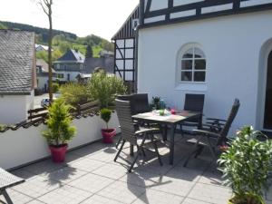 een patio met een tafel, stoelen en planten bij Majestic apartment in Olsberg in Olsberg