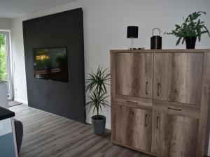 a living room with a large wooden cabinet and a tv at Nice apartment in Neuenkirchen in Neuenkirchen