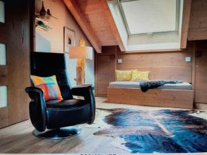 ein Wohnzimmer mit einem Stuhl und einem Bett in der Unterkunft Apartment in Garmisch-Partenkirchen in Garmisch-Partenkirchen