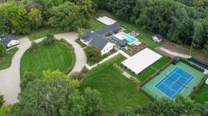 uma vista aérea de uma propriedade com um campo de ténis e uma piscina em Apple Blossom Resort By Dwell Vacations em New Buffalo