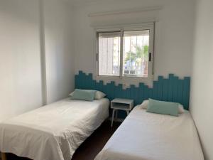 מיטה או מיטות בחדר ב-Acogedor apartamento en primera línea de playa
