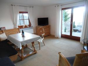 a living room with a table and a tv at Lovely apartment in Berchtesgaden in Berchtesgaden