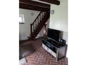 ein Wohnzimmer mit einem TV und einer Treppe in der Unterkunft Lovely apartment in Straelen in Straelen