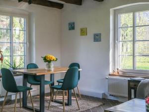 ein Esszimmer mit einem Tisch und grünen Stühlen in der Unterkunft Lovely apartment in Straelen in Straelen