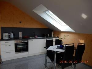 a kitchen with white cabinets and a table with chairs at Holiday apartment Moselle Panorama in Enkirch
