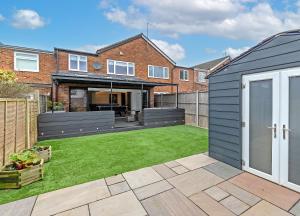 a garden with a lawn in front of a house at Contractors Dream~POOL TABLE~Close to Luton Airport~Three Double Bedrooms in Luton