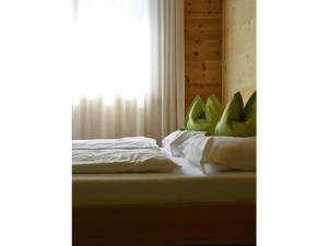 1 cama con sábanas blancas y ventana en Holiday apartment Rohrhardsberg, en Elzach