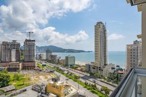 uitzicht op een stad met gebouwen en de oceaan bij Excelente apto luxuoso a 3 min da praia DBR0805 in Itapema