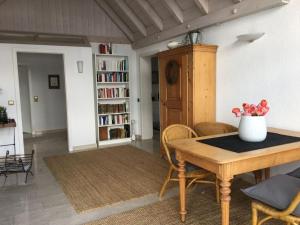 een woonkamer met een tafel en stoelen en een boekenplank bij Apartment in Sasbach - Jechtingen in Jechtingen