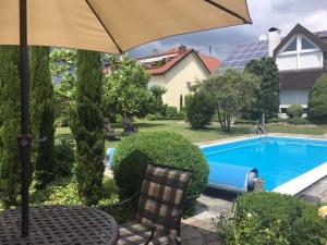 een tafel met een parasol naast een zwembad bij Apartment in Sasbach - Jechtingen in Jechtingen