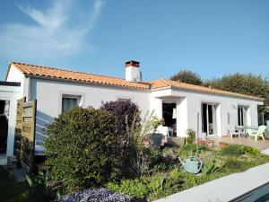 ein weißes Haus mit einem Garten davor in der Unterkunft La P'tite Etape in Talmont