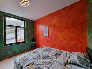 Schlafzimmer mit roten und grünen Wänden und einem Bett in der Unterkunft Bella vista in Durbuy