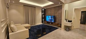 A television and/or entertainment centre at شقة أنيقة مودرن بدخول ذكي و سطح بجلسة خارجية
