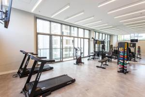 a gym with treadmills and exercise equipment and windows at Domy in Sao Paulo