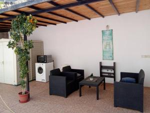 un soggiorno con sedie, tavolo e forno a microonde di Jardín de Sandra a San Sebastián de la Gomera