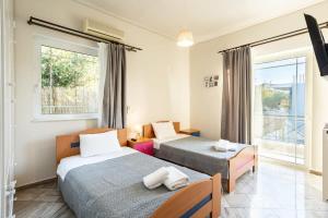 1 dormitorio con 2 camas y ventana en Verga SeaBliss - Mariellen's Relaxing Destination, en Verga Kalamata