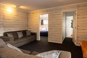 sala de estar con sofá y dormitorio en Haka Lodge Taupo, en Taupo